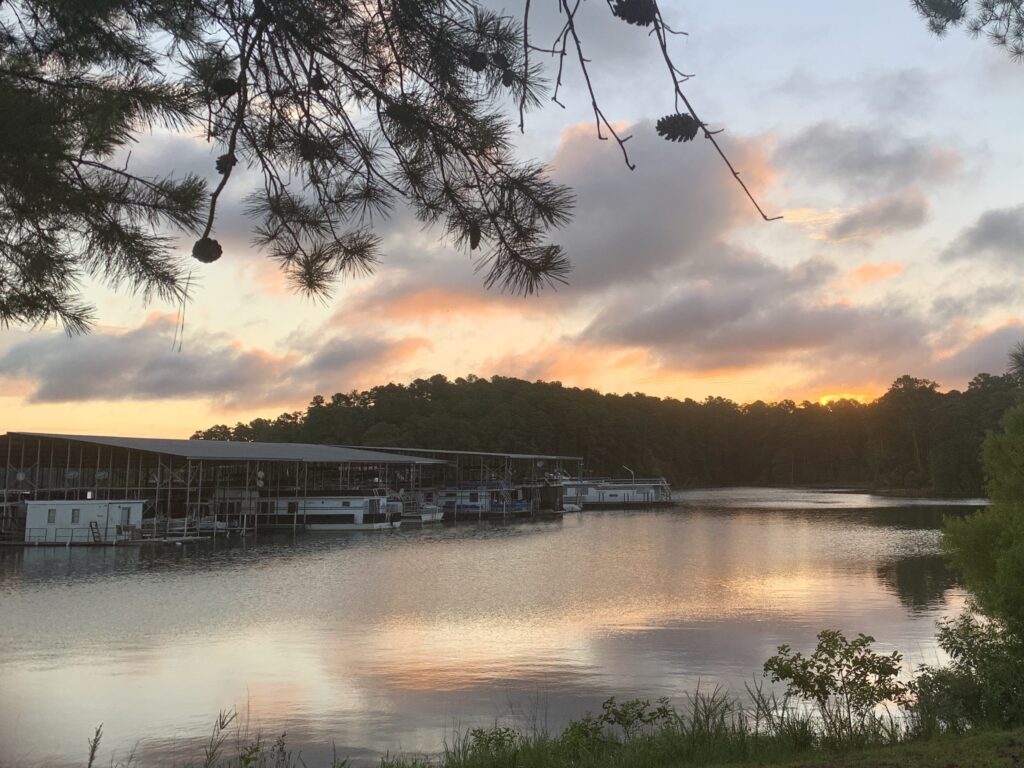 A scenic view of a lake with a boat dock at sunset Camping on Lake Thurmond, South Carolina